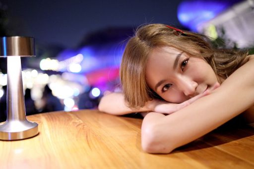 机にうつ伏せになってこちらを見る女性