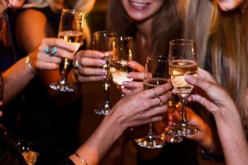 お酒の吐いたグラスで乾杯する女性達の手元