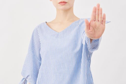 手のひらを前に突き出す女性