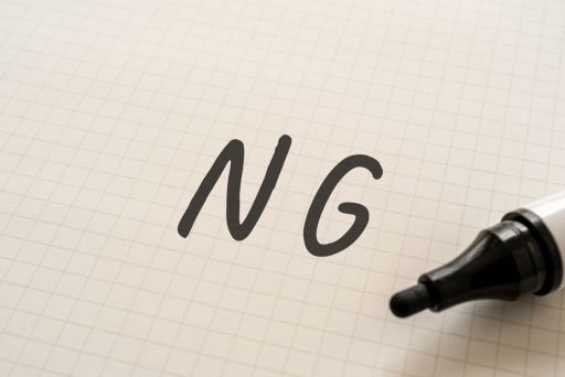 紙に書かれたNGの文字と黒いマーカー