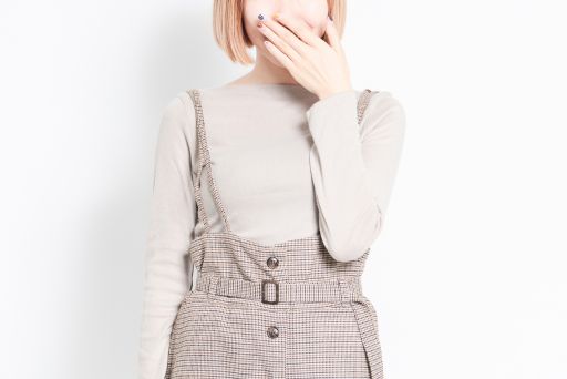 口元に手を当てるピンクの髪の女性