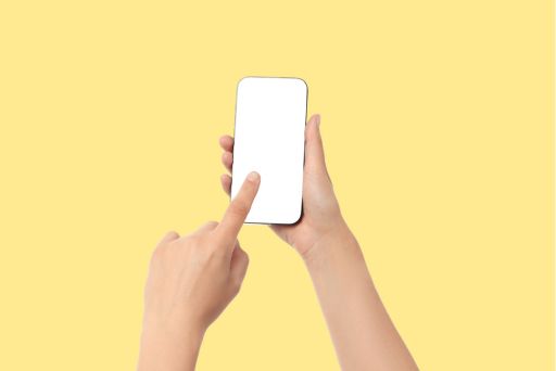 黄色い背景にスマホを触る人