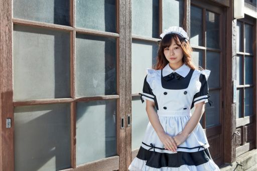 壁際に立つメイド服の女性