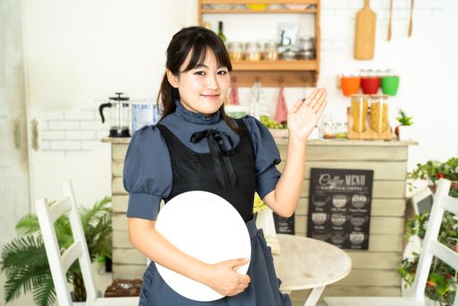 お盆を持っているメイド服の女性