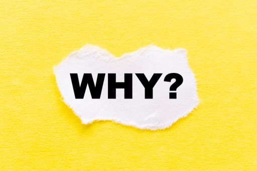 WHY?と書かれた紙と黄色い背景