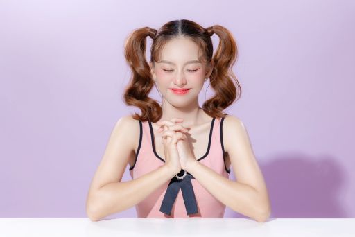 祈るツインテールの女性