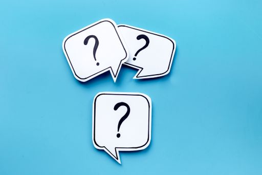 水色の背景の前にある3つのハテナマーク