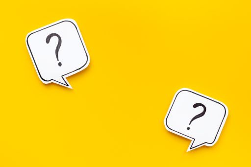 黄色の背景の前にある2つのハテナマーク