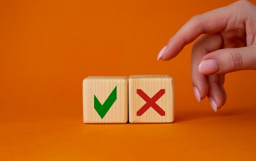 チェックマークとバツマークのブロックを取ろうとしている女性