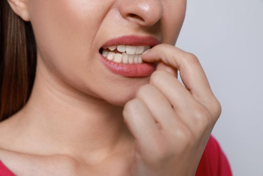 指をかんで悔しそうにする女性