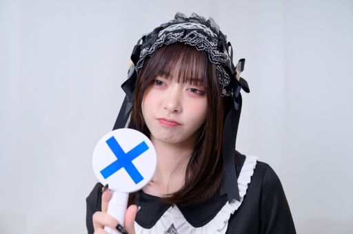 バツ印のカードを持ったコンカフェ嬢