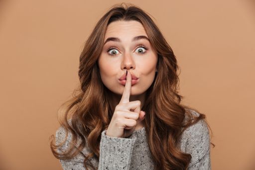 口を人差し指で抑える女性