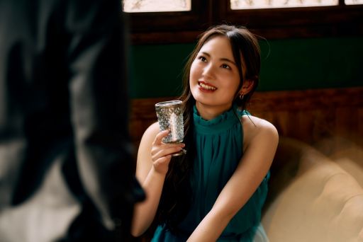 お酒を持って男性と話す女性