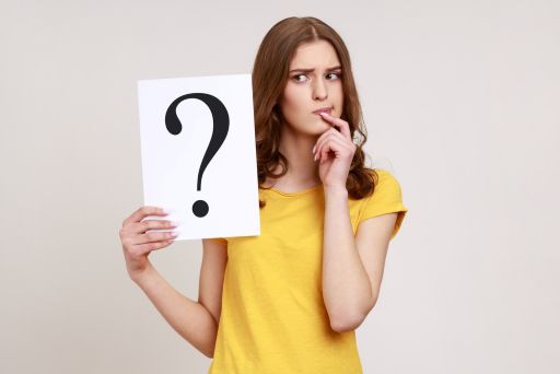 はてなマークを持つ女性