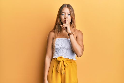 口の前で人差し指を当てる女性