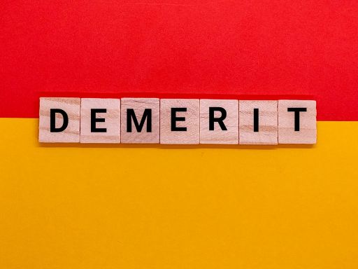 赤と黄色の背景にあるDEMERITと書かれたブロック