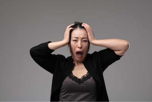 頭を抱えて叫んでいる様子の女性