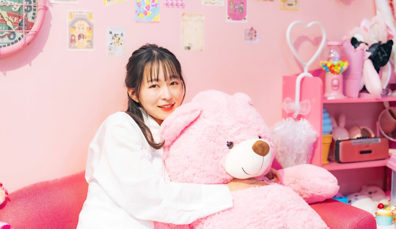 ピンクの熊のぬいぐるみを抱く女性