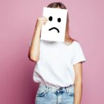 悲しい顔の紙を持っている女性