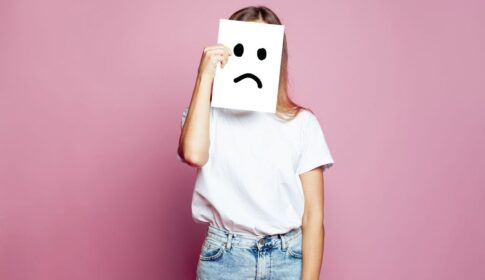 悲しい顔の紙を持っている女性