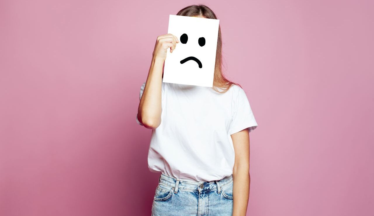 悲しい顔の紙を持っている女性