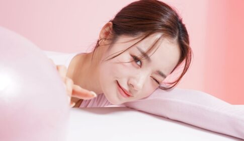 ピンクの風船を少し触ろうとしている女性