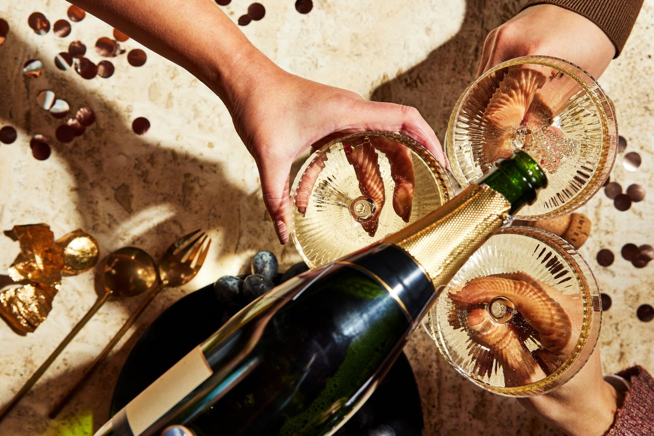 グラスにシャンパンを注ぐ女性の手