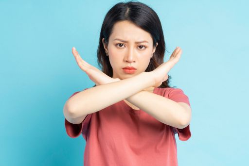 身体の前でバツのサインをとる女性