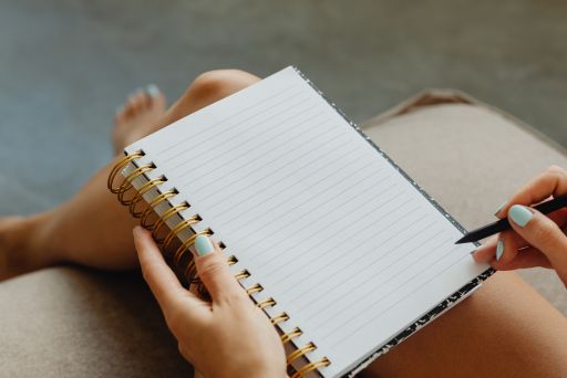 ノートに何かを書こうとする女性の手