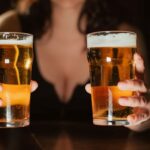 ビールグラスを2つ持つ女性