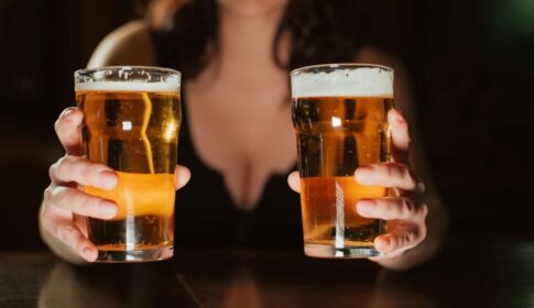 ビールグラスを2つ持つ女性