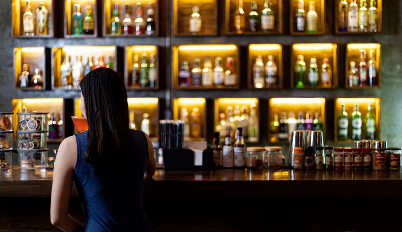 バーカウンターに座る女性の後ろ姿