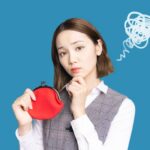 赤いお財布を持ちながら悩む女性