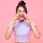 両手を口元にあて何かを叫ぶ女性